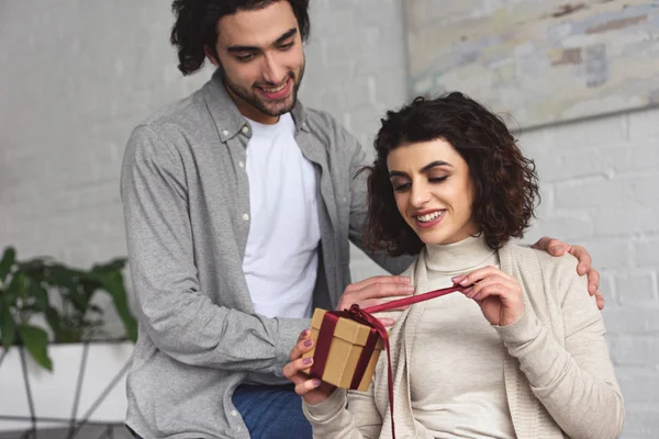 Boyfriend presenting gift to girlfriend at home — Stock Photo
