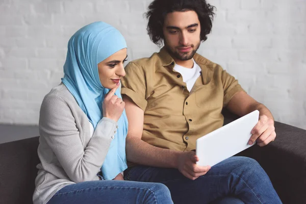 Muslimisches Paar nutzt Tablet im Wohnzimmer — Stockfoto