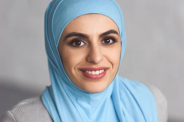Retrato de sonriente hermosa mujer musulmana en hijab en casa - foto de stock