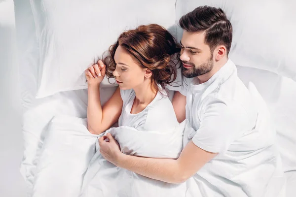 Vista aérea de jovem casal dormindo na cama juntos — Fotografia de Stock