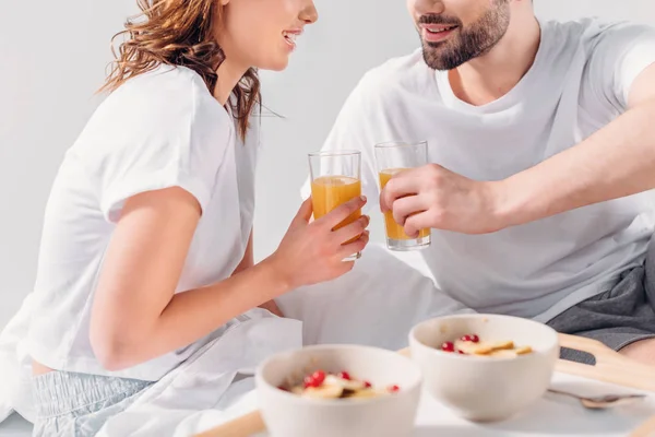 Vue partielle du couple prenant le petit déjeuner au lit le matin ensemble — Photo de stock