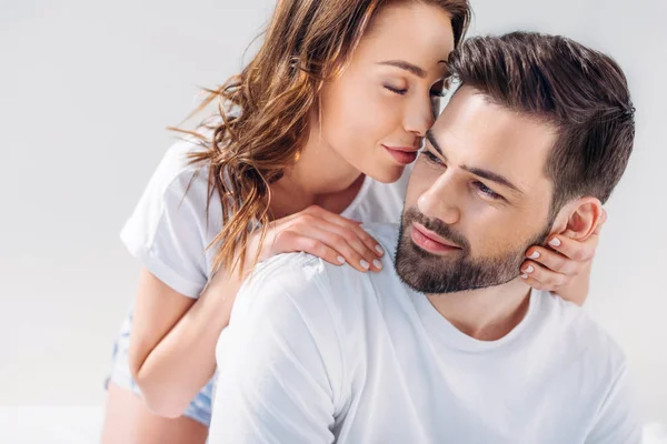 Young tender woman hugging boyfriend isolated on grey — Stock Photo