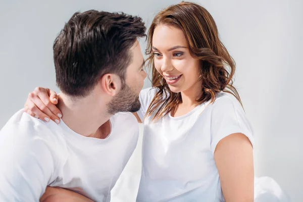 Young pretty woman hugging boyfriend isolated on grey — Stock Photo