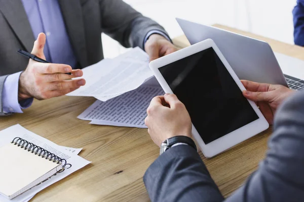Imagen recortada de empresarios sosteniendo tableta y documentos en la oficina - foto de stock