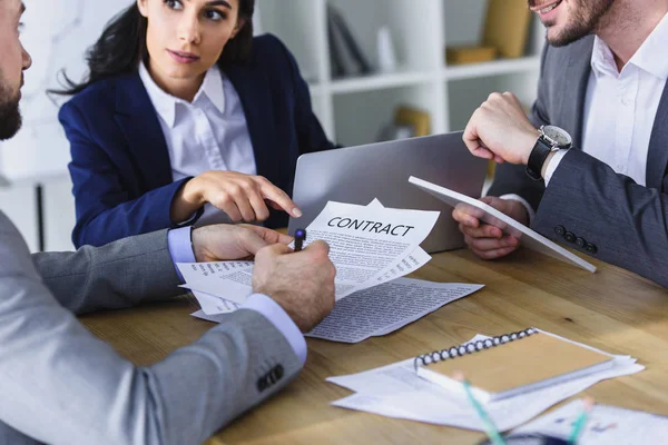 Обрізане зображення бізнесменів, які обговорюють контракт за столом в офісі — стокове фото