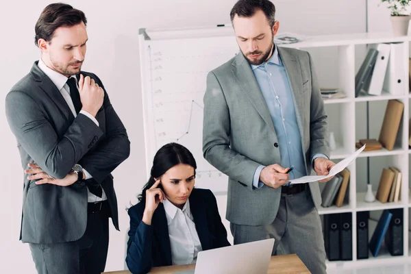 Besonnene Geschäftsleute schauen im Büro auf Laptop — Stockfoto