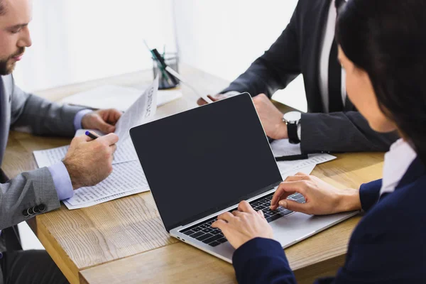 Cropped image of businesspeople working with laptop in office — Stock Photo