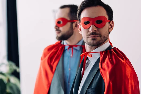 Portrait of handsome super businessmen in masks and capes in office — Stock Photo