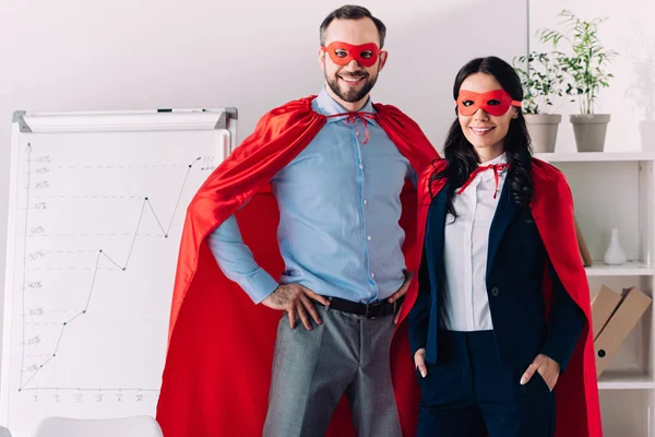 Sourire super homme d'affaires et super femme d'affaires regardant la caméra dans le bureau — Photo de stock