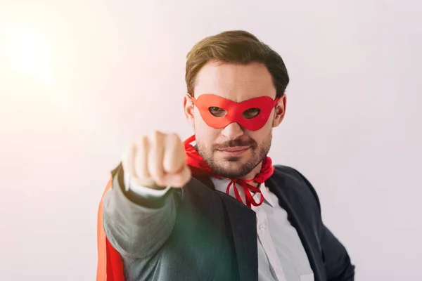 Beau super homme d'affaires en masque et cape montrant poing isolé sur blanc — Photo de stock