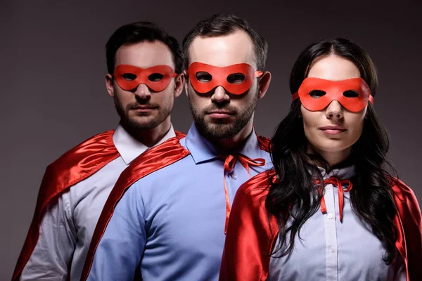 Super hommes d'affaires en masques et capes regardant la caméra isolée sur gris — Photo de stock