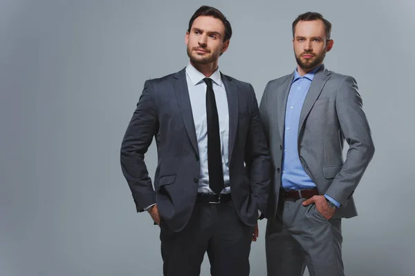 Seriöse, gut aussehende Geschäftsleute isoliert auf grau — Stockfoto