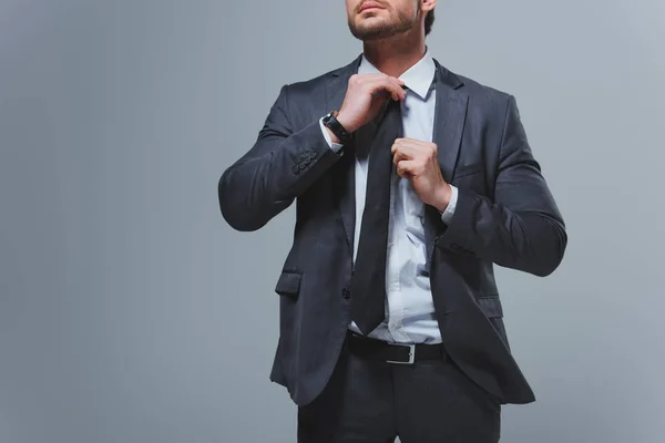 Abgeschnittenes Bild von Geschäftsmann, der Krawatte isoliert auf Grau fixiert — Stockfoto