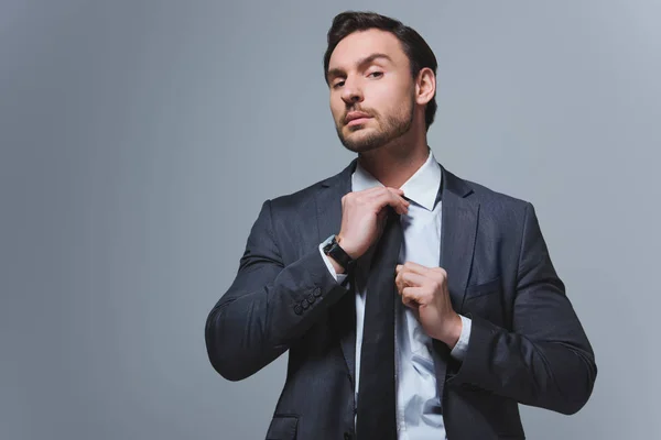 Schöner Geschäftsmann mit Krawatte und Blick in die Kamera isoliert auf grau — Stockfoto