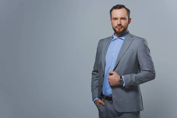 Gutaussehender Geschäftsmann blickt isoliert auf graue Kamera — Stockfoto