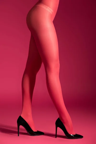 Mulher sensual em meias de nylon vermelho no fundo vermelho — Fotografia de Stock