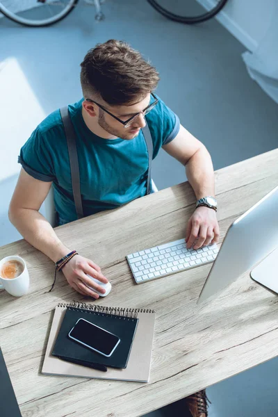 Vista aerea di giovane freelance in occhiali che lavorano con computer fatto col personal computer — Foto stock
