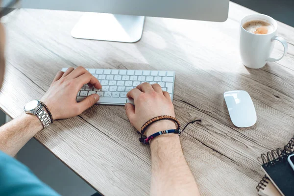 Recortado disparo de hombre escribiendo en el teclado y trabajando con el ordenador de escritorio - foto de stock