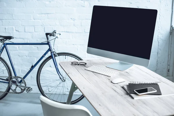 Lieu de travail moderne avec ordinateur de bureau et électronique sur table — Photo de stock