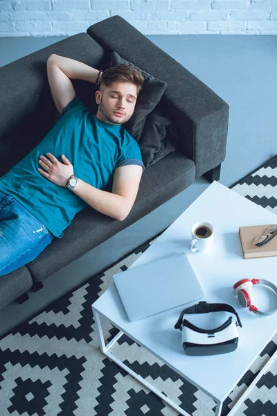 High angle view of handsome young man sleeping on couch at home — Stock Photo