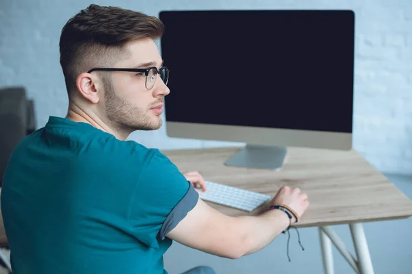 Uomo libero professionista in occhiali a lavoro da tavolo con computer — Foto stock