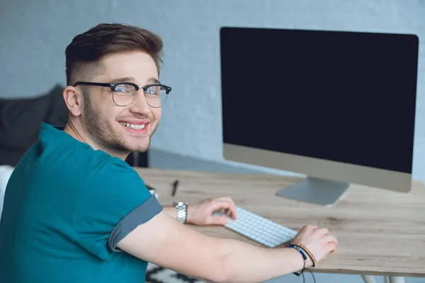 Lächelnder Designer, der am Tisch mit dem Desktop-Computer arbeitet — Stockfoto