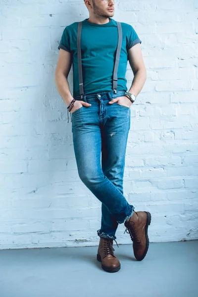 Attractive young man wearing jeans with suspenders — Stock Photo