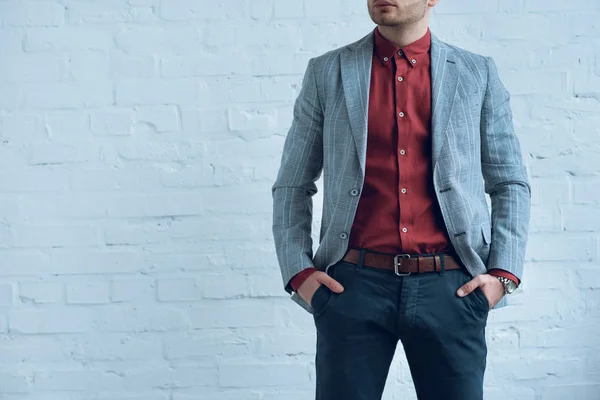 Attractive bearded man wearing suit standing in front of brick wall — Stock Photo