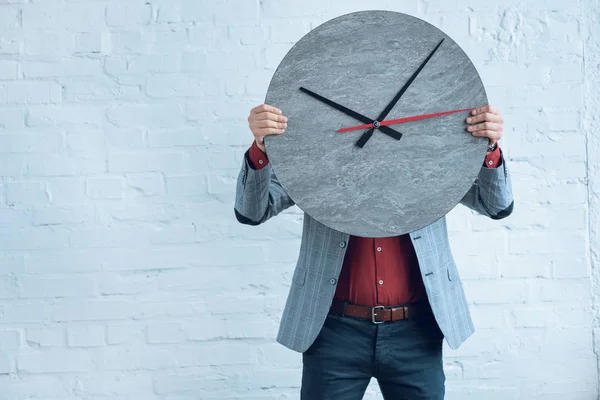 Große Uhr in Männerhänden an der Ziegelwand — Stockfoto