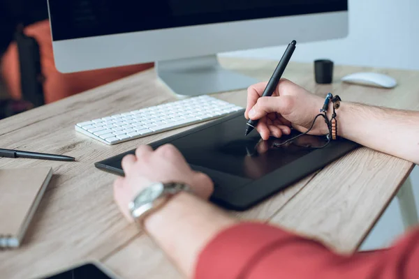 Mann zeichnet mit digitalem Tablet am Computer auf Tisch — Stockfoto