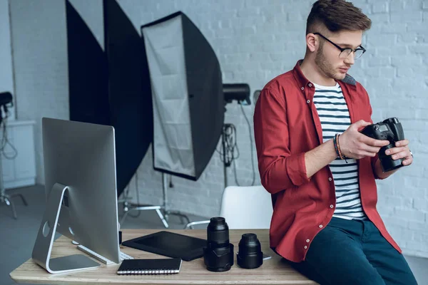 Joven fotógrafo usando cámara profesional - foto de stock