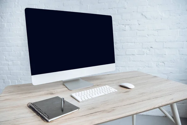 Компьютер с ноутбуком на столе в светлом офисе — стоковое фото
