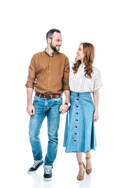 Visão comprimento total do casal feliz de mãos dadas e sorrindo uns aos outros isolado no branco — Fotografia de Stock