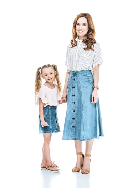 Hermosa feliz madre e hija cogidas de la mano y sonriendo a la cámara aislada en blanco - foto de stock