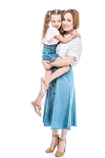 Happy mother carrying adorable little daughter and smiling at camera isolated on white — Stock Photo