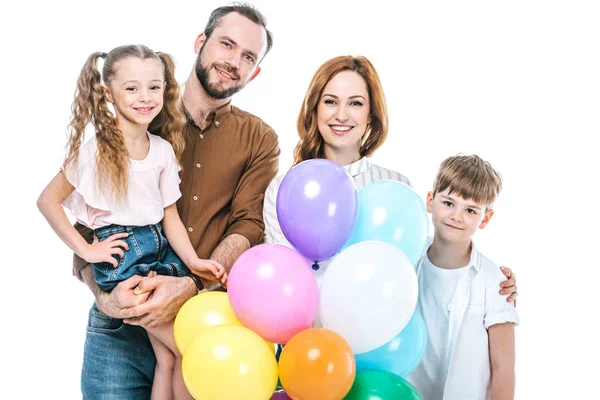 Happy family with two kids holding colorful balloons and smiling at camera isolated on white — Stock Photo