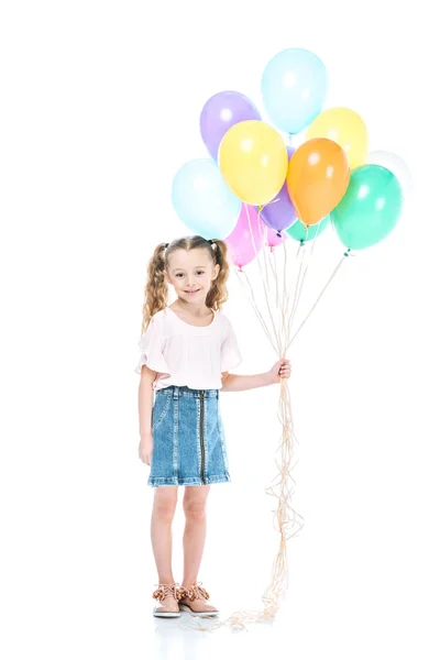 Vue pleine longueur de beau petit enfant tenant des ballons colorés et souriant à la caméra isolée sur blanc — Photo de stock