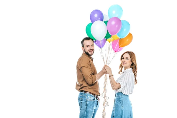 Casal feliz segurando balões coloridos e sorrindo para a câmera isolada no branco — Fotografia de Stock