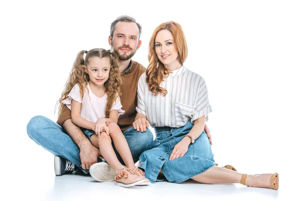 Famille heureuse avec un enfant assis ensemble et souriant à la caméra isolé sur blanc — Photo de stock
