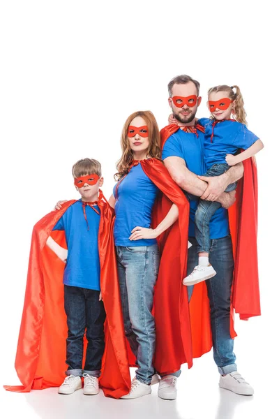 Super família em máscaras e capas de pé juntos e olhando para a câmera isolada no branco — Fotografia de Stock