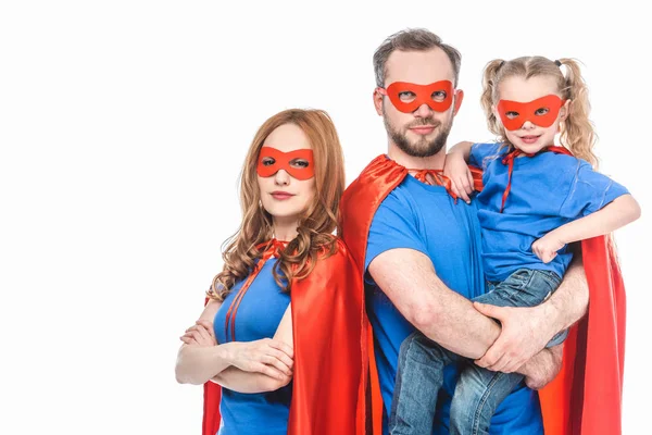 Super parents with little daughter wearing masks and cloaks and looking at camera isolated on white — Stock Photo