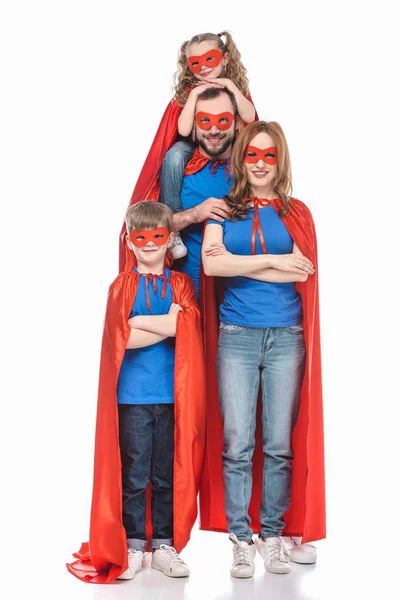 Alegre super familia en máscaras y capas sonriendo a la cámara aislada en blanco - foto de stock