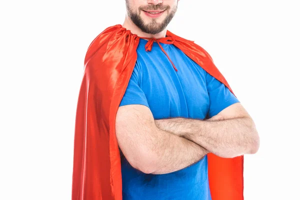 Recortado disparo de sonriente hombre en traje de superhéroe de pie con los brazos cruzados aislados en blanco - foto de stock