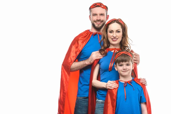 Happy family in superhero costumes standing together and smiling at camera isolated on white — Stock Photo