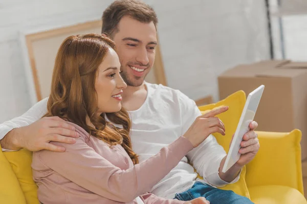 Feliz pareja joven utilizando tableta digital durante la reubicación - foto de stock