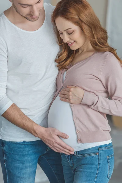 Tiro cortado de homem feliz tocando barriga de esposa grávida — Fotografia de Stock