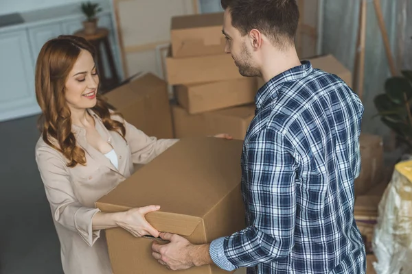 Young couple with cardboard box at new home, moving house concept — Stock Photo