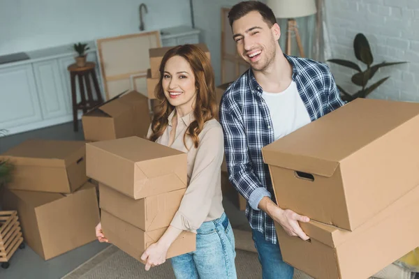 Porträt eines jungen Paares mit Pappkartons im neuen Zuhause, Umzugskonzept — Stockfoto