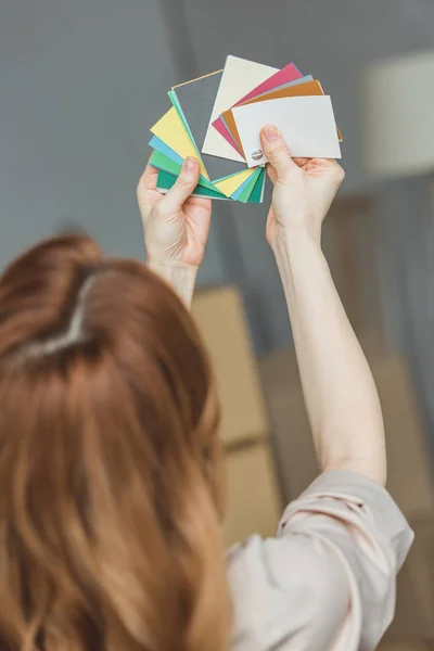 Vue arrière de la femme choisissant la couleur pour la chambre à la nouvelle maison, concept de relocalisation — Photo de stock