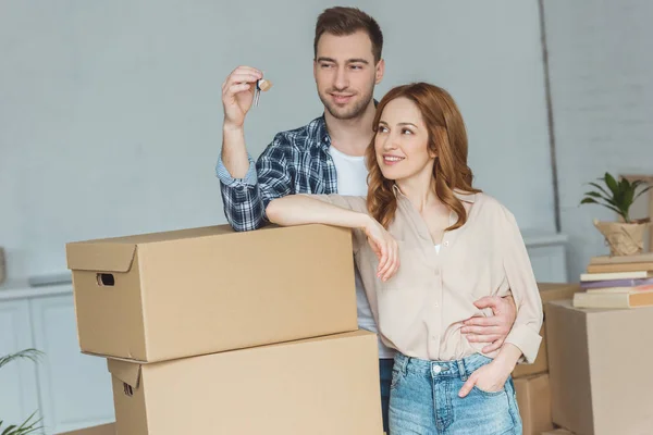 Retrato de casal sorridente olhando para as chaves do novo apartamento, conceito de realocação — Fotografia de Stock